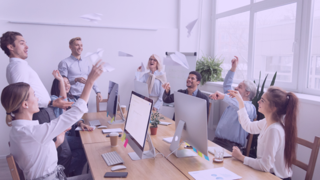Equipe em volta da mesa comemorando resultados alcançados por ser produtiva - 5 maneiras eficientes de aumentar a produtividade da sua equipe 